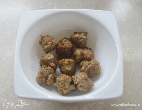 В глубокую посуду для приготовления омлета выложите фрикадельки.