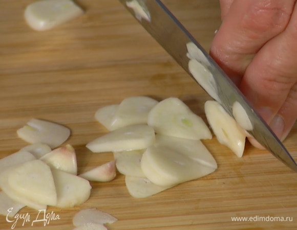 Чеснок почистить и нарезать тонкими пластинками.