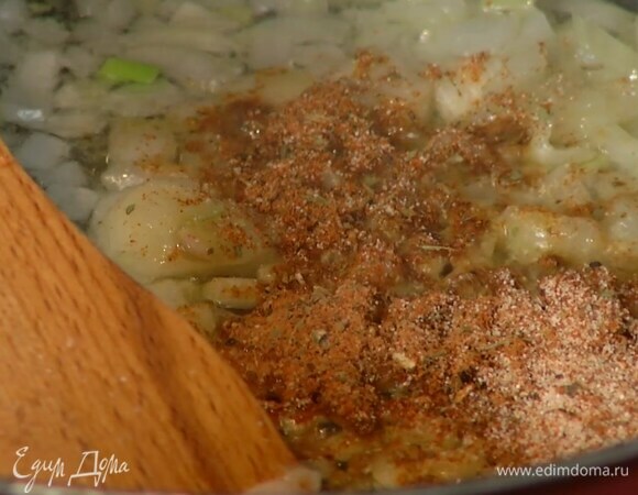 В глубокой сковороде разогреть оливковое масло и обжарить лук и чеснок до золотистого цвета, затем всыпать все сухие специи и, помешивая, немного прогреть.