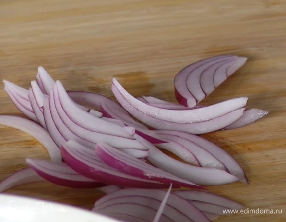 Красный лук почистить, нарезать тонкой соломкой, залить яблочным уксусом и дать постоять.