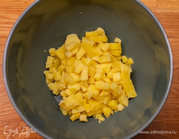 Отваренный картофель нарезать кубиками в большую чашу.