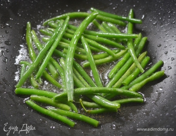 На сковороде разогрейте масло, добавьте фасоль и обжаривайте ее 2–3 минуты.