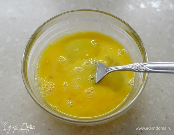 В отдельной посуде слегка взбейте вилкой яйца.