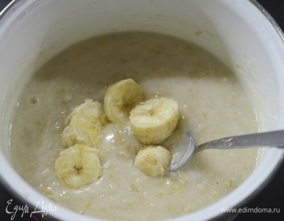 Банан почистите, нарежьте кружками и 1/3 добавьте в кашу.