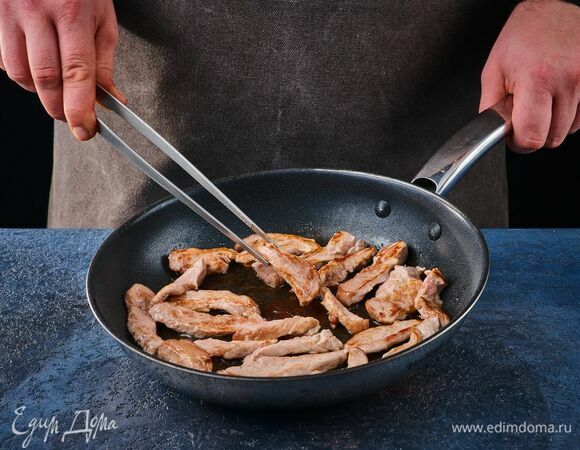 Свинину нарежьте тонкими полосками и обжарьте на сковороде в течение 10 минут. Не забывайте постоянно помешивать.