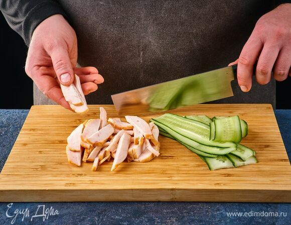 Копченое куриное филе нарежьте соломкой, свежий огурец нашинкуйте тонкими слайсами.