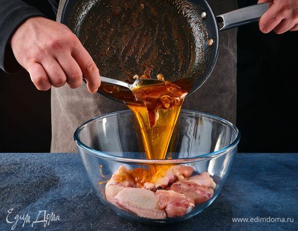 В глубокую миску выложите крылышки, равномерно распределите маринад и оставьте на 30 минут.