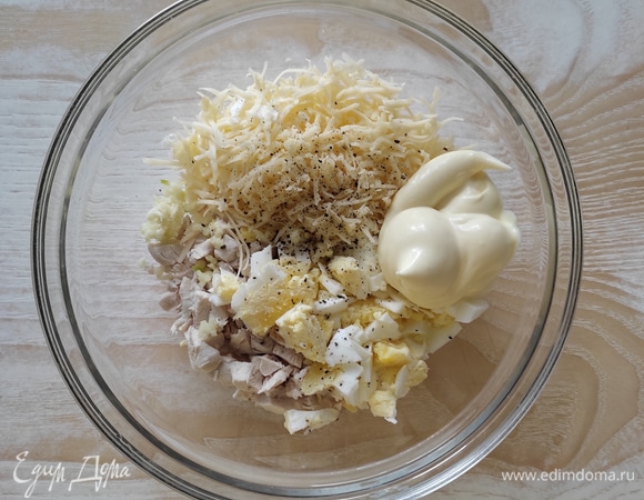 В чашу выложить нарезанные мелким кубиком отварное куриное филе и яйца, натертый на мелкой терке сыр. Выдавить через пресс зубчик чеснока, добавить по вкусу соль и черный молотый перец, майонез и хорошо перемешать.