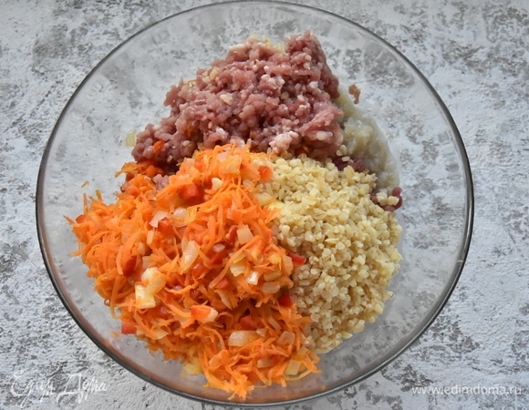 В подготовленный фарш добавляю половину пассерованных овощей, булгур, соль, хмели-сунели. Перемешиваю.