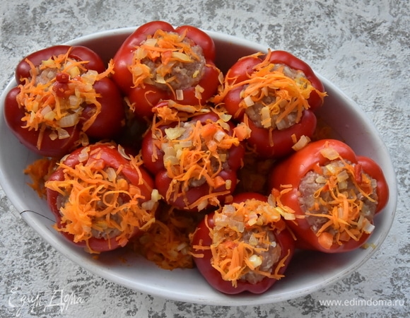 Начиняю перцы подготовленной начинкой и устанавливаю в форму для запекания. Сверху распределяю оставшиеся пассерованные овощи.