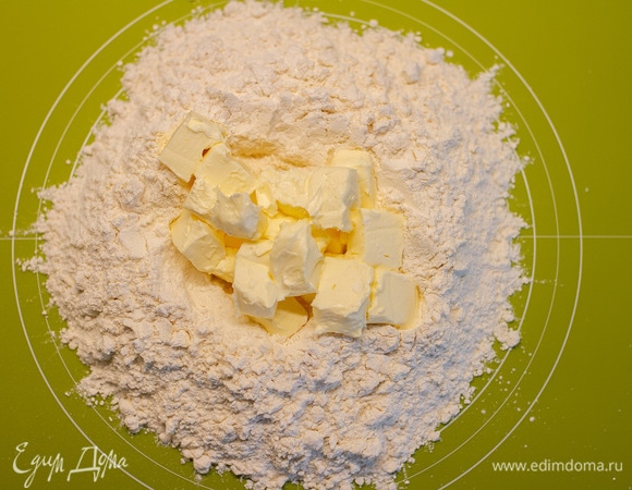Масло нарезать крупными кубиками, добавить к муке. Порубить ножом.