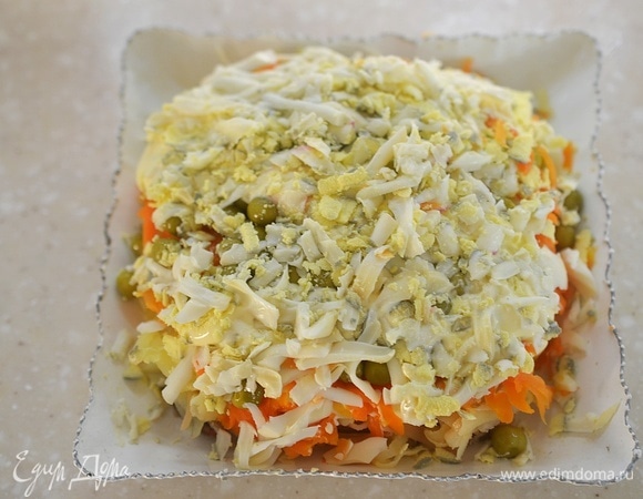 Яйца отварите вкрутую, натрите на терке и выложите на горошек.