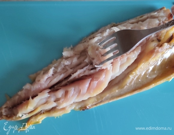 Я использовала скумбрию холодного копчения. Тушку очистить от кожицы, внутренностей (если есть), костей. Разобрать рыбку на волокна — удобнее это делать вилкой.