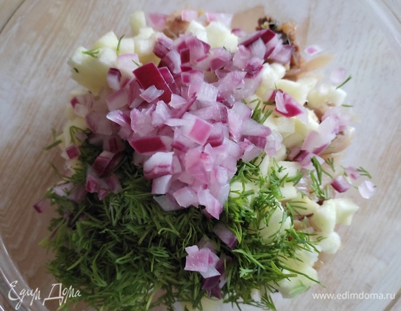 В чаше смешать кусочки рыбы, лук, яблоко и зелень. Перемешать.