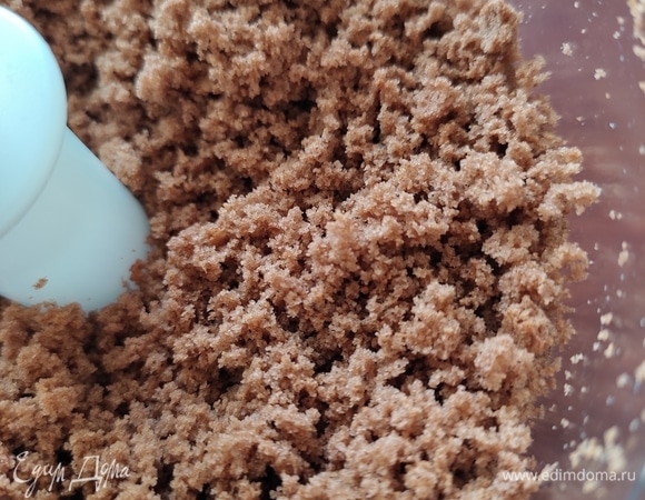Остывший бисквитный корж ломаем на кусочки, складываем в чашу измельчителя и перетираем в крошку. Можно это сделать вручную.