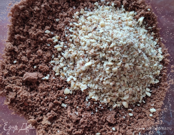 В бисквитную крошку добавляем мелко порубленные грецкие орехи, хорошо перемешиваем.