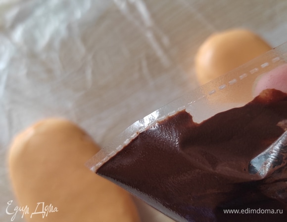 Дольки шоколада переложить в кондитерский мешок (можно взять маленький файлик, так как шоколада немного), завязать и поместить в кружку с кипятком — так шоколад быстро растает, не перегреется и не свернется.