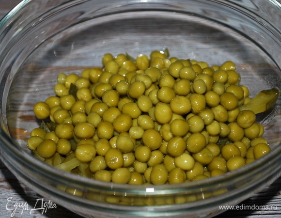 Маринованные огурцы нарежьте на тонкие полоски, к огурцам добавьте консервированный зеленый горошек.