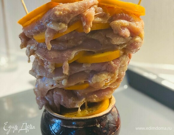 На 3 деревянные шпажки, которые лучше предварительно замочить в воде, насадить поочередно мясо и хурму. Установить в горшок для запекания и поставить на противень.