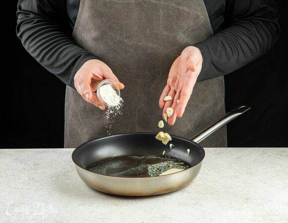 В отдельной сковороде разогрейте сливочное масло, обжарьте рубленый чеснок и муку. Добавьте бульон.