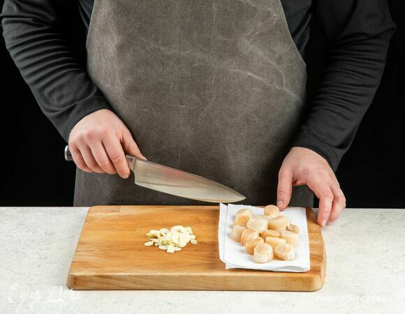 Морские гребешки предварительно разморозьте, промойте и подсушите бумажным полотенцем. Чеснок нарежьте слайсами.