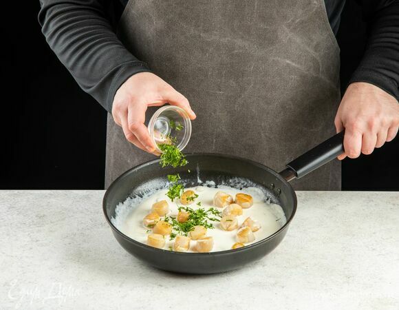 Верните гребешки в соус, добавьте рубленую петрушку, прогрейте в течение 1 минуты.