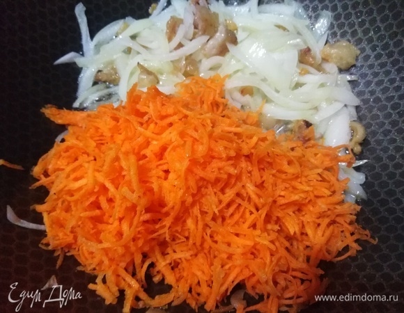 Всыпать нарезанный репчатый лук, обжарить до прозрачности. Добавить натертую морковь.