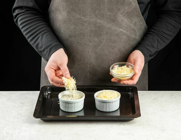 Выложите грибную массу в рамекины. Сверху посыпьте тертым сыром.<br />
Запекайте жюльен с шампиньонами в духовке около 10 минут при 200°C.