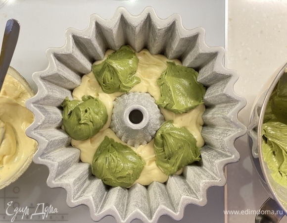 В форму для выпекания выложить слой белого теста, затем — цветное (ложками), далее — слой белого. Повторить.