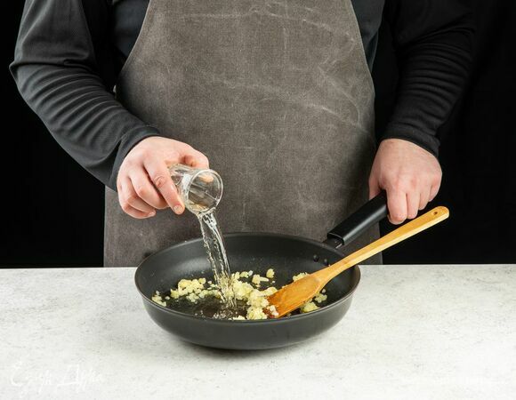 Влейте в сковороду белое вино, перемешайте.