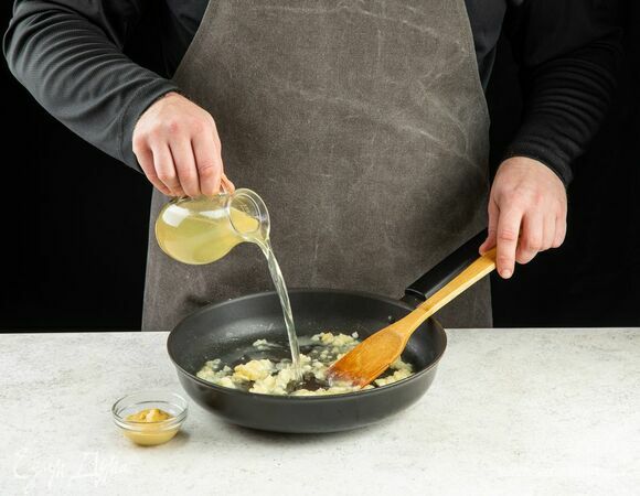 Добавьте бульон и горчицу. Томите на медленном огне, постоянно помешивая.