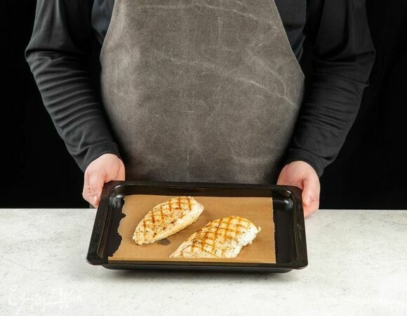 Переложите грудку на противень, застеленный пергаментом. Отправьте в разогретую до 180°C духовку на 10–12 минут.