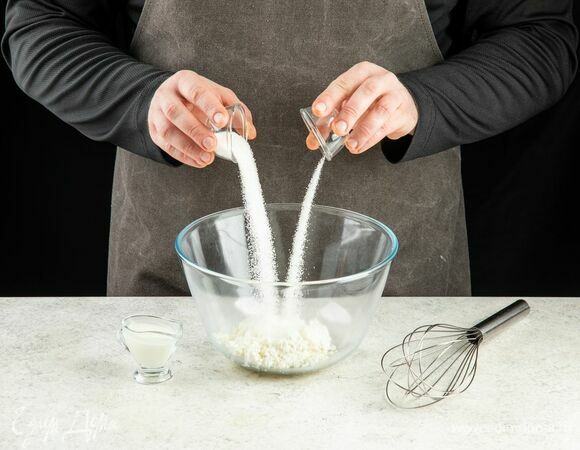 В глубокую миску выложите творог, йогурт, сахар и ванильный сахар. Взбейте до однородной консистенции и полного растворения сахара.