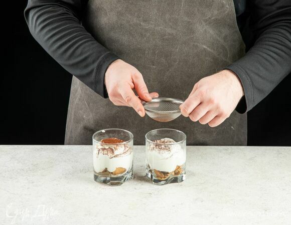 Сверху на печенье положите крем, далее просейте через сито немного какао.<br />
По желанию повторите слои, заполнив стакан полностью. Постарайтесь, чтобы сверху остался слой крема.<br />
Украсьте десерт какао-порошком и поставьте в холодильник на 1 час.