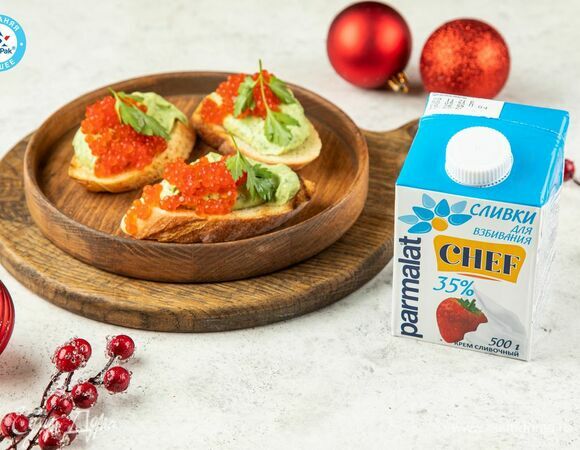 Выложите на ломтики багета мусс из авокадо и красную икру. Украсьте листочками зелени и подавайте!