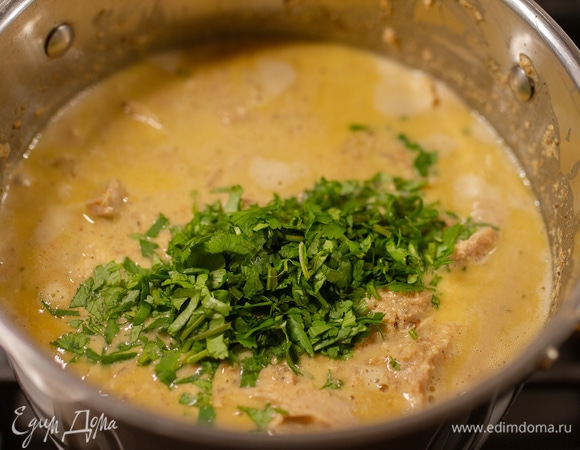 Кинзу мелко нарезать. Чеснок очистить и пропустить через пресс. Добавить чеснок и кинзу в соус. Перемешать и снять с огня.