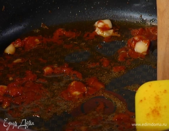 Разогреть в сотейнике оливковое масло, выложить нарезанный чеснок и томатную пасту и перемешать, затем всыпать зиру, паприку и тмин, добавить нут, все перемешать и прогреть на небольшом огне.