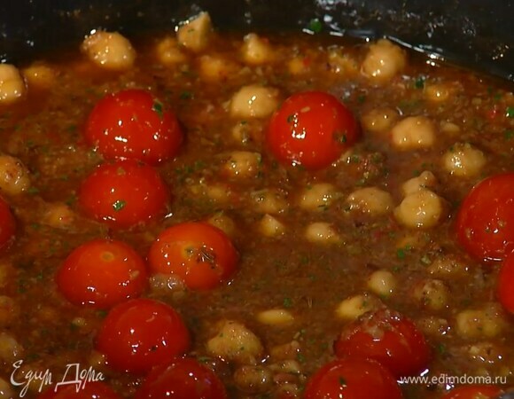 Половину оливкового соуса выложить в сотейник с нутом, все перемешать, влить бульон и немного прогреть, затем добавить помидоры черри и, помешивая, прогревать на маленьком огне.