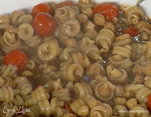 Воду из фунгетти слить и сохранить, макароны добавить в сотейник с нутом и перемешать, влить немного сохраненной воды, еще раз перемешать и переложить в глубокую миску.