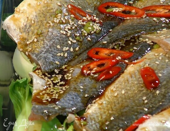 Овощи вынуть из духовки, выложить на них рыбу кожей вверх, полить все соусом, посыпать перцем чили и оставшимся кунжутом, плотно накрыть форму фольгой и поставить в духовку еще на 15 минут.
