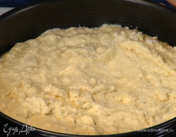 Дно разъемной формы для выпечки выстелить пищевой бумагой, выложить тесто и разровнять его.