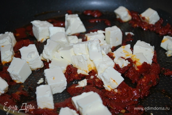 Фету нарежьте кубиками, добавьте в сковороду, аккуратно перемешайте с томатной пастой и уберите с огня.