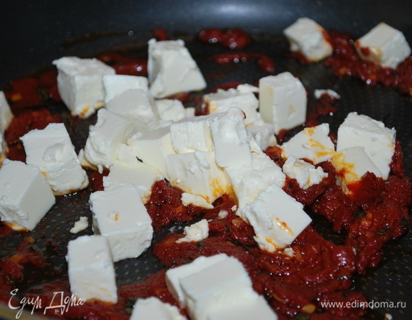 Фету нарежьте кубиками, добавьте в сковороду, аккуратно перемешайте с томатной пастой и уберите с огня.