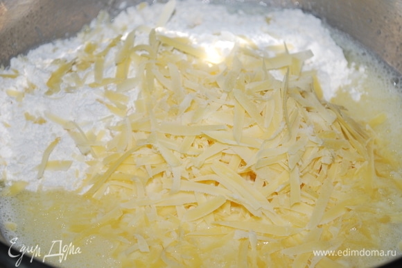В глубокой миске слегка взбейте яйца с молоком и растительным маслом. Добавьте муку с разрыхлителем, солью и перцем. Сыр натрите на крупной терке, добавьте, перемешайте.