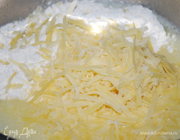 В глубокой миске слегка взбейте яйца с молоком и растительным маслом. Добавьте муку с разрыхлителем, солью и перцем. Сыр натрите на крупной терке, добавьте, перемешайте.