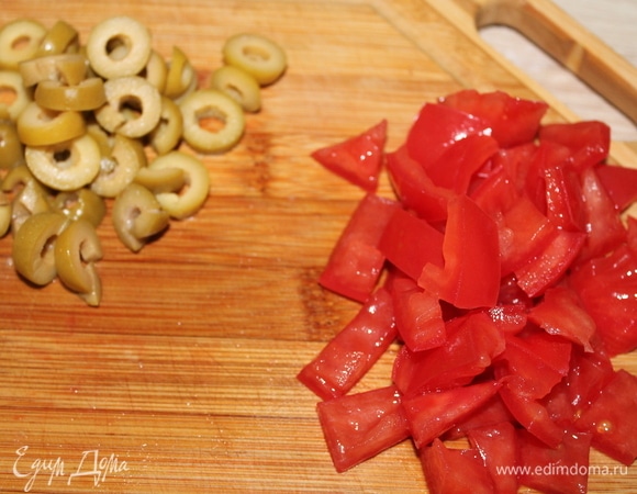 Нарезаем оливки и помидор.