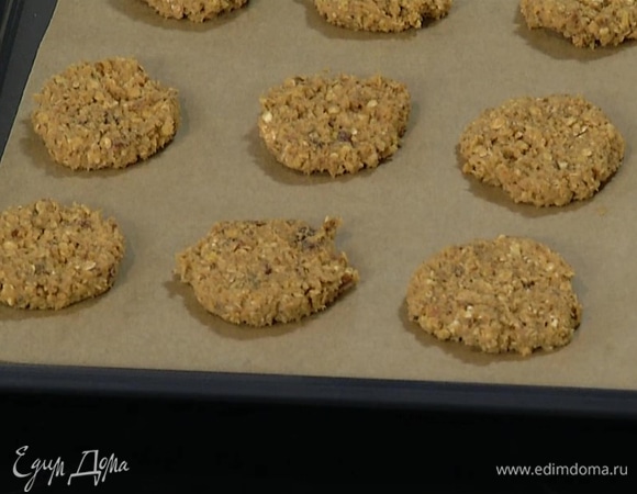 Сделать из теста небольшие лепешки и выложить на застеленный бумагой для выпечки противень.