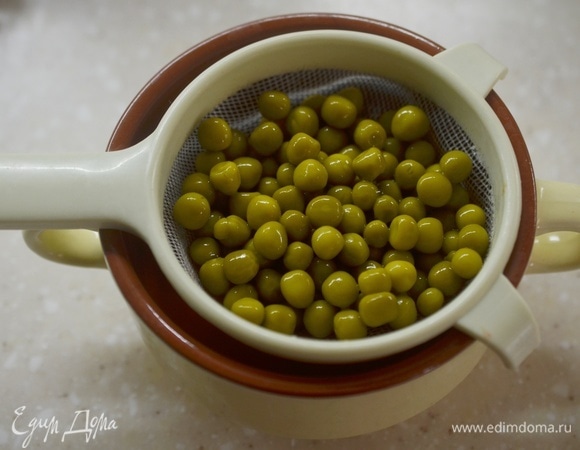 Горошек откиньте на сито, чтобы слить лишнюю жидкость.