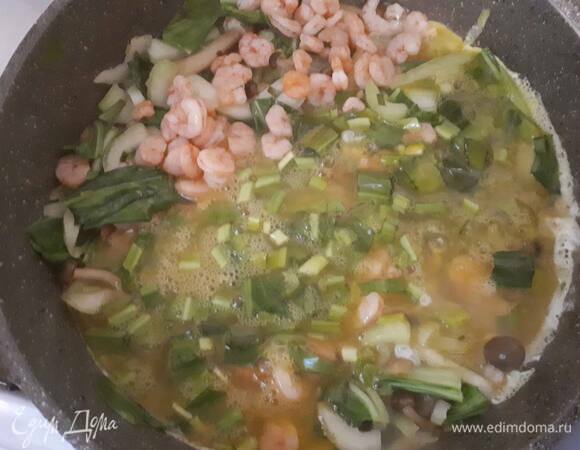 Влейте яйца в сковородку и добавьте креветки (лучше брать мелкие).