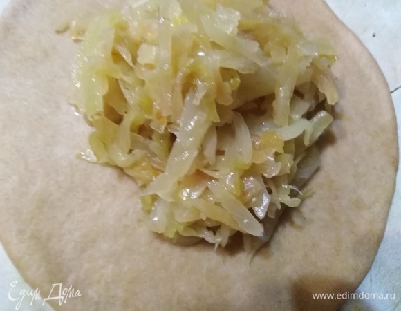 Раскатать каждую часть в лепешку. На середину выложить капусту.